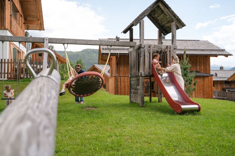Familie spielt mit Kindern auf dem Spielplatz